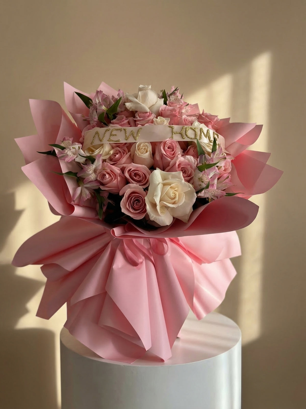 Bouquet of pink and white roses with a 'New Home' card, wrapped in pink paper, by Floréalo, a local miami florist.